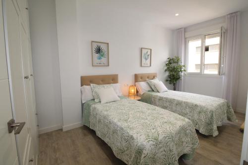 sypialnia z 2 łóżkami i oknem w obiekcie Del Parque Flats Puerto w Maladze