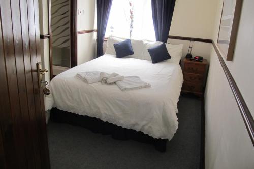 a bedroom with a bed with towels on it at Burnt Mill Cottage in Burnham on Crouch