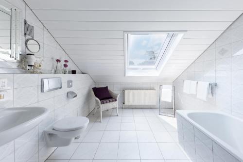 a white bathroom with a sink toilet and a window at Hotel Alte Post in Krefeld