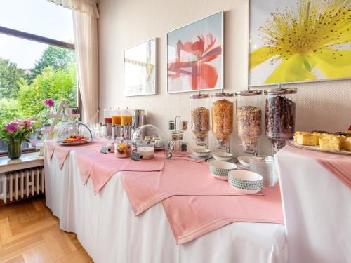 a table with a pink table cloth and food at Hotel Alte Post in Krefeld