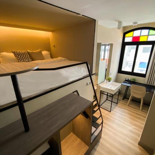 a bedroom with a bunk bed and a room with a desk at ST Signature Jalan Besar, SHORT OVERNIGHT, 13 Hours, 6PM-7AM in Singapore