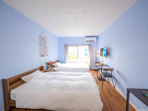 a bedroom with two beds and a window at Hotel Shion no Umi - Vacation STAY 98886 in Miyako Island