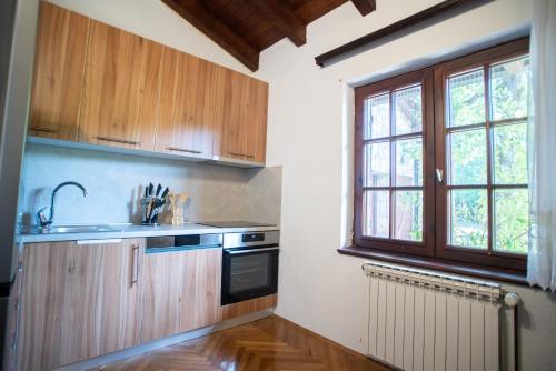 a kitchen with wooden cabinets and a sink and a window at Villa Amalia in Široki Brijeg