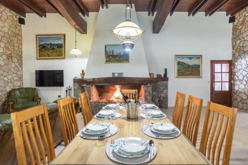 a dining room with a table and chairs and a fireplace at Villa Amalia in Široki Brijeg