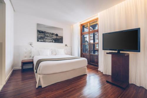 a hotel room with a bed and a flat screen tv at Iberostar Heritage Grand Mencey in Santa Cruz de Tenerife
