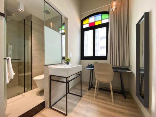 a bathroom with a sink and a toilet and a window at ST Signature Jalan Besar, SHORT OVERNIGHT, 13 Hours, 6PM-7AM in Singapore