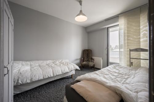 une chambre avec deux lits et une fenêtre dans l'établissement Trimaran, à Courseulles-sur-Mer