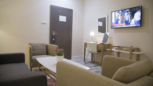 a living room with couches and a tv on the wall at The Best Centric Hotel in Nouakchott