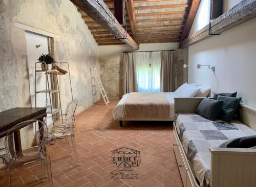 a bedroom with a bed and a couch in a room at Agriturismo Borgo Buzzaccarini Rocca di Castello in Monselice