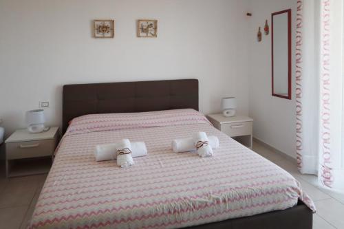 1 dormitorio con 1 cama grande y 2 toallas en B&B Torre Nave, en Praia a Mare