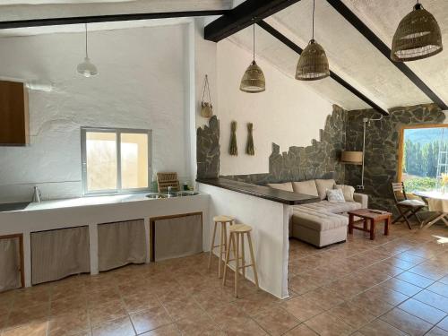 a kitchen and living room with a couch and a table at Casa Rural El Carrizal in Riópar