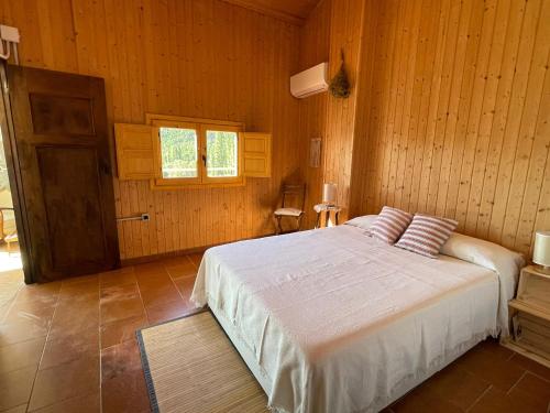 1 dormitorio con 1 cama en una habitación de madera en Casa Rural El Carrizal en Riópar