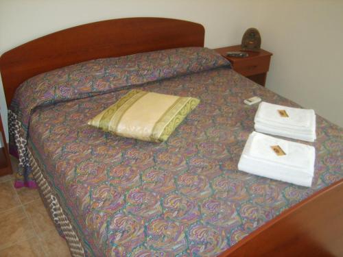 a bed with two towels and a pillow on it at Antica Vittoria in Vittoria