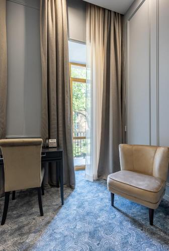 a room with a chair and a desk and a window at Dvoryansky Hotel in Odesa