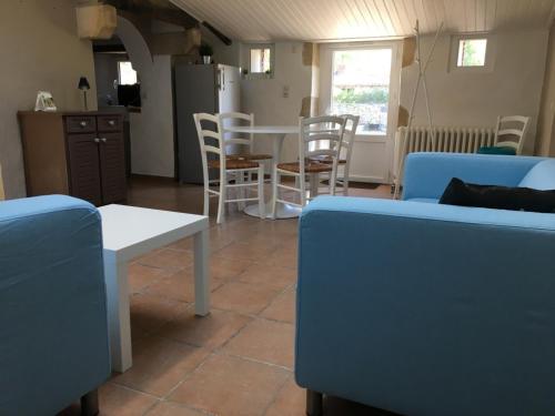 a living room with chairs and a table and a kitchen at La Frouardière, 3 gîtes de charme in Antigny