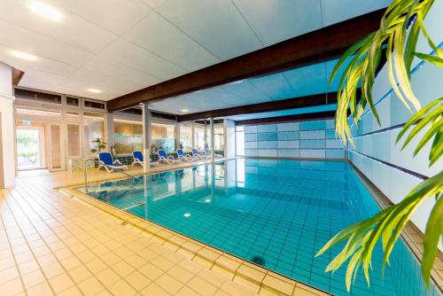 a large swimming pool with blue tile walls and a tile floor at Wellnesshotel Sonnenhof & Sonnhalde in Ühlingen-Birkendorf