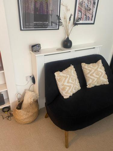a black chair with pillows in a living room at Central Brighton garden studio, close to seafront in Brighton & Hove