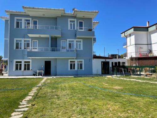 a house with a yard in front of it at Parli Hotel in Gokceada Town