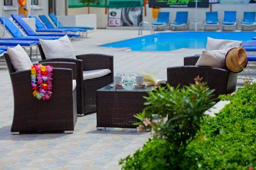a group of chairs and a table next to a pool at Paloma Hotel Apartments in Ayia Napa