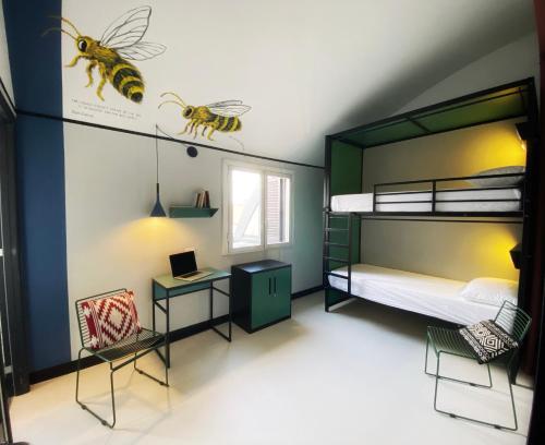 - une chambre avec des lits superposés, un bureau et un lit avec des abeilles dans l'établissement YellowSquare Milan, à Milan