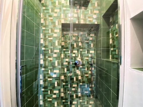 a bathroom with a shower with green and brown tiles at CAMPOREGIO 31- In Centro con Vista sul Duomo in Siena
