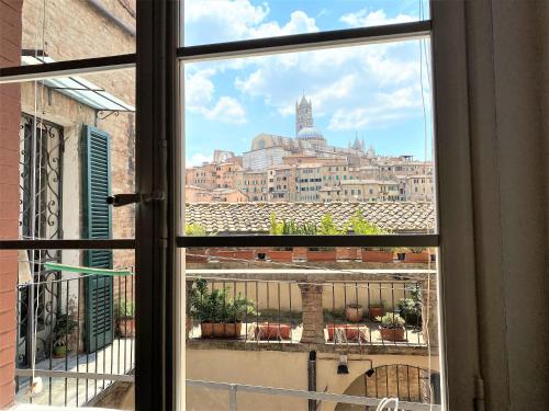 a view of a city from a window at CAMPOREGIO 31- In Centro con Vista sul Duomo in Siena