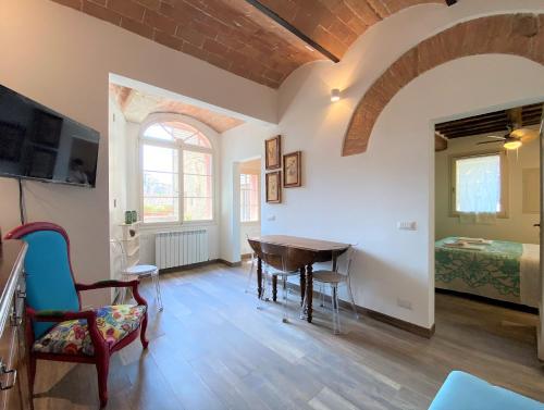 a room with a table and chairs and a bedroom at CAMPOREGIO 31- In Centro con Vista sul Duomo in Siena