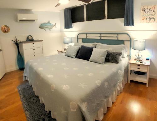1 dormitorio con 1 cama grande con colcha blanca en Maui Tranquility II, en Kihei