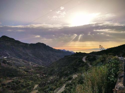 a view of a mountain valley with the sun setting at Casa Leon in Tejeda