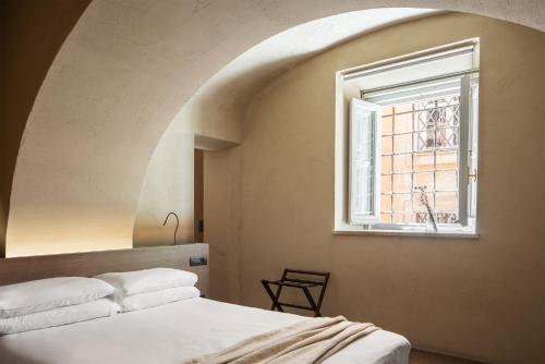 a bedroom with a bed and a window at Hotel dei Barbieri in Rome