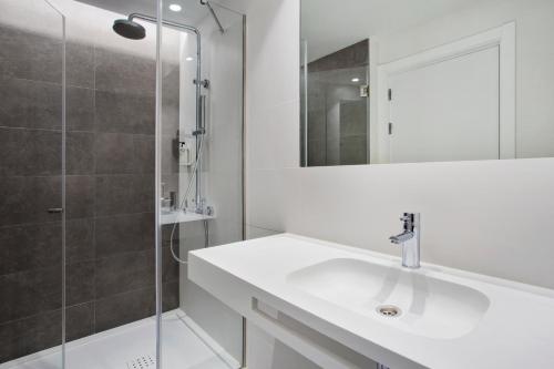 a bathroom with a sink, mirror, and bathtub at B&B Hotel Porto Expo Aeroporto in Matosinhos