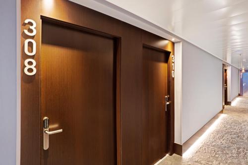 a row of brown doors in a hallway at B&B HOTEL Porto Expo Aeroporto in Matosinhos