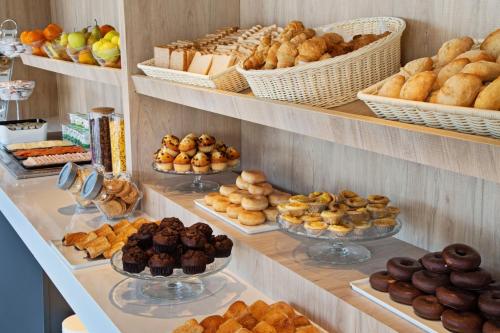 a bakery with shelves filled with different types of pastries at B&B HOTEL Porto Expo Aeroporto in Matosinhos