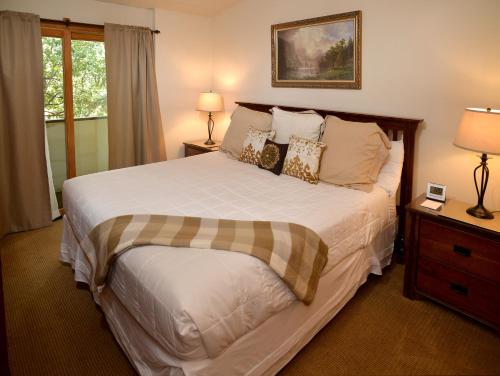 a bedroom with a large bed and two lamps at Lionshead Arcade #303 Condo in Vail