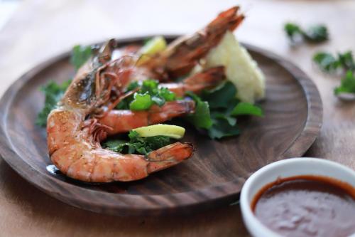 a plate of food with shrimp and vegetables and dipping sauce at The Ambassador, Marine Drive, Mumbai in Mumbai