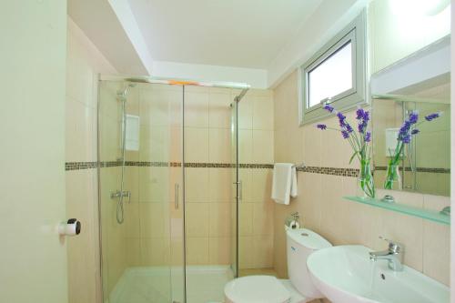 a bathroom with a shower and a toilet and a sink at Paloma Hotel Apartments in Ayia Napa
