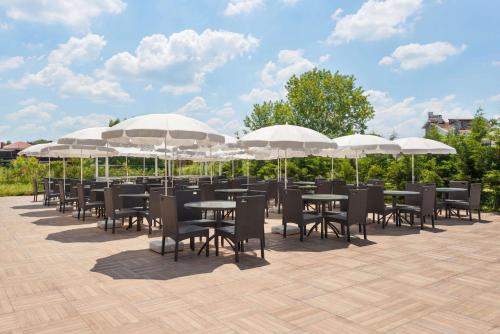 a row of tables and chairs under umbrellas at Ramada by Wyndham Istanbul Sile in Sile