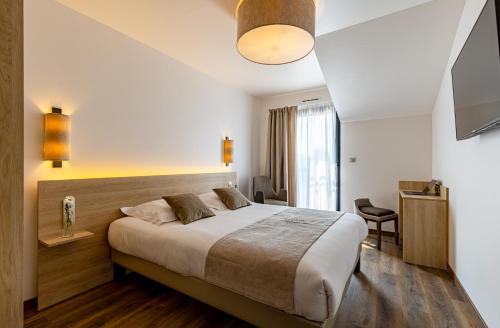 a bedroom with a large bed in a room at Hôtel SPA du Lac de Madine - Maison DRAPIER in Heudicourt-sous-les-Côtes