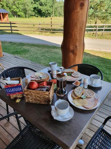 a picnic table with a basket of food on it at Rakši in Cēsis