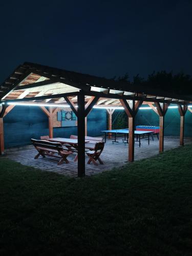 a group of picnic tables under a pavilion at night at Oázis Üdülő Tiszafüred in Tiszafüred