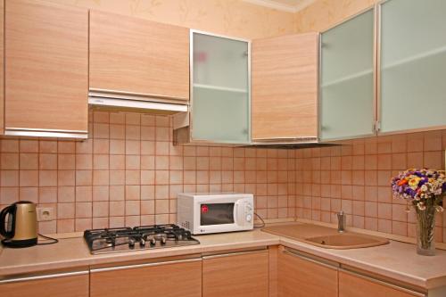 a kitchen with a stove and a microwave on a counter at Villa Balgatura Concept Hotel & Apartaments in Hurzuf