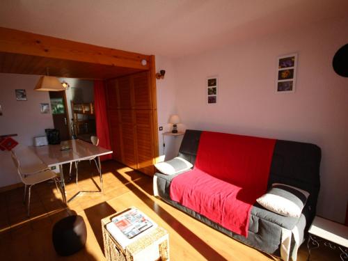 un soggiorno con letto rosso e tavolo di Studio Les Saisies, 1 pièce, 4 personnes - FR-1-293-157 a Les Saisies