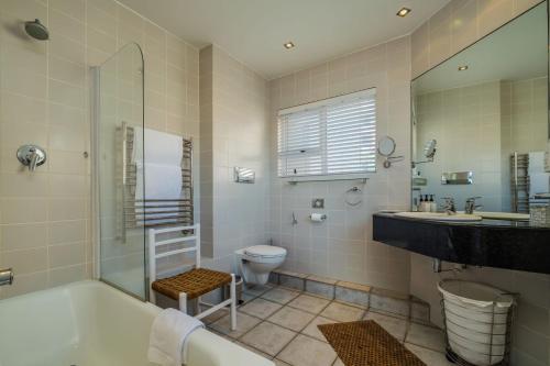 a bathroom with a tub and a toilet and a sink at Camps Bay Terrace Penthouse in Cape Town