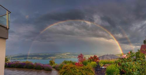 un arco iris en el cielo sobre un cuerpo de agua en Belair Beinwil - B&B, en Beinwil