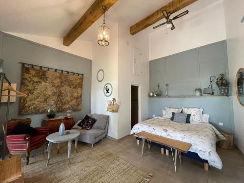 1 dormitorio con cama, sofá y mesa en Chez Brunet chambres d'hôtes et gîte, en Gondrin