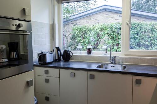 a kitchen with a sink and a window at Vakantiebungalow Texel in De Cocksdorp