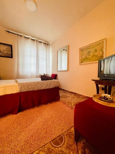 a bedroom with a bed and a tv in a room at Katalin Panzió in Budapest