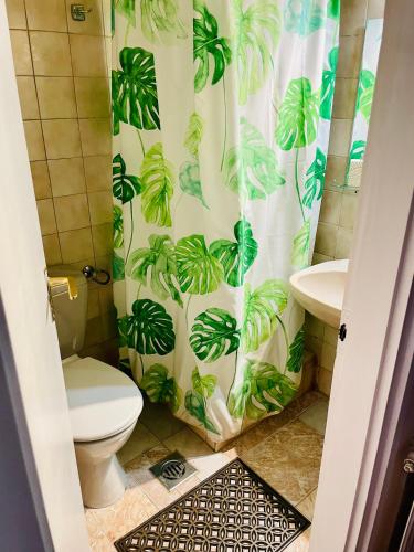 a bathroom with a shower curtain with a toilet and a sink at Katalin Panzió in Budapest