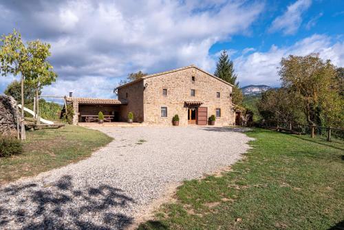 an external view of a stone house with a gravel driveway at Casa Rural Moixella in Lladurs