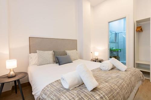 a bedroom with a large white bed with towels on it at Nine O'Clock Metrosol by Valcambre in Seville
